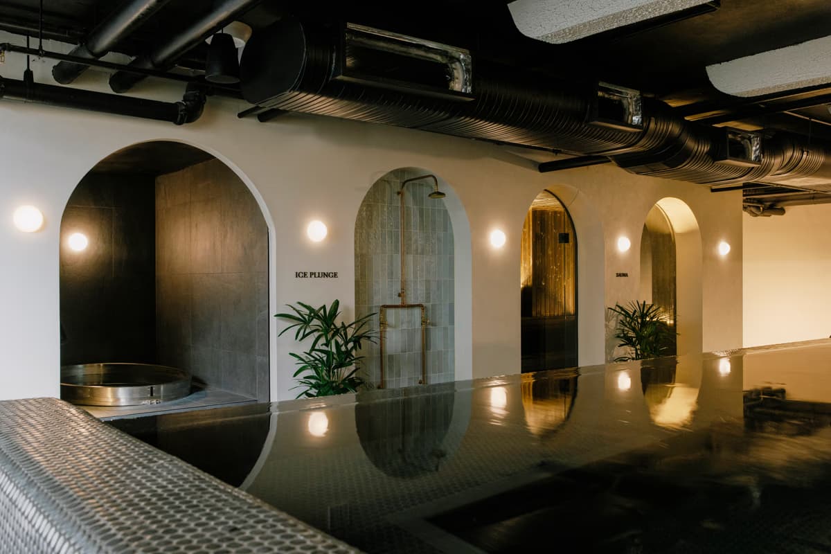 Warmly lit pool, arches and sauna in the Navia Bathhouse Byron Bay interior